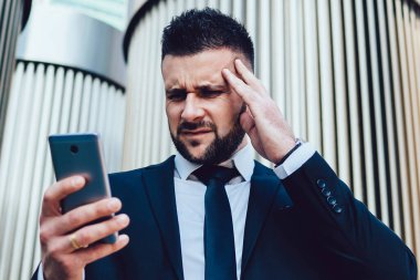 Yorgun iş adamı cep telefonundan mesaj okurken baş ağrısı çekiyor. Akıllı telefondan gelen e-posta uyarısı kafasını karıştırırken eli ile kafasına dokunan yorgun erkek girişimci