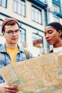 Gündelik giyinmiş çok kültürlü turistler ellerinde seyahat haritası tutarak yeni kasabalarda gösteri yerleri arıyorlar. Hafta sonları geziye çıkan genç erkek ve kadın gezginler