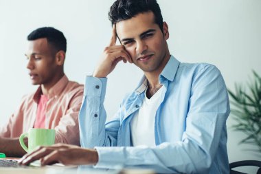 İspanyol erkek metin yazarlarının portresi modern dizüstü bilgisayarda uygulama için makale hazırlamak için zaman harcıyor, veritabanı bilgileriyle online çalışan çok kültürlü programcılar