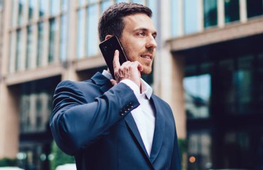 Resmi giyinmiş beyaz bir adam uluslararası akıllı telefon konuşmaları yapıyor iş projesini tartışıyor, akıllı erkek şirket müdürü modern mobil cihaz aracılığıyla telefon etmek için 4G 'yi kullanıyor.