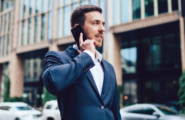 Resmi giyinmiş beyaz bir adam uluslararası akıllı telefon konuşmaları yapıyor iş projesini tartışıyor, akıllı erkek şirket müdürü modern mobil cihaz aracılığıyla telefon etmek için 4G 'yi kullanıyor.