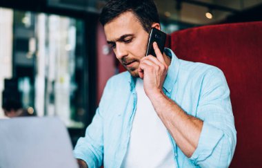 Ciddi bir serbest çalışan bilgisayar antivirüsü hakkında danışmanlık için müşteri hizmetlerini arıyor, erkek programcı cep telefonu uygulaması üzerinden telefon ederken bilgiyi başlatıyor