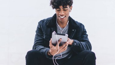 Neşeli milenyum hipster 'ı tanıtım geçmişi olan şehir merdivenlerinde dinleniyor ve favori müzik podcast' inin ses kitaplarıyla uygulama yüklemek için boş zaman harcamasını dinliyor.