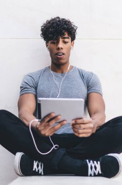 Gündelik giysiler içinde yakışıklı hippi adam sosyal reklamcılık için fotokopi alanı olan şehir ortamında blog yazarları için online webinar izliyor, promosyon geçmişine yakın milenyum adamı