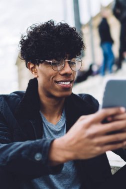 Neşeli seyahat blogcusu, İspanyol tatilleri hakkında sosyal takipçilerle sanal iletişimde eğleniyor. Açık havada dinlenirken posta kontrol etmek için 4G kablosuz internet kullanan yakışıklı bir adam.