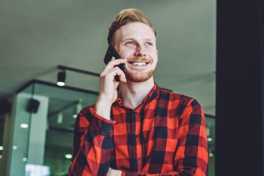 Kafkasyalı mutlu bir adam internet üzerinden iletişim kurmak için cep telefonuyla arkadaşa seslenirken, yakın arkadaşı içeride oturuyor ve öğreniyor, teknoloji kavramı ve jenerasyon