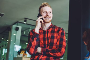 Kafkasyalı mutlu bir adam internet üzerinden iletişim kurmak için cep telefonuyla arkadaşa seslenirken, yakın arkadaşı içeride oturuyor ve öğreniyor, teknoloji kavramı ve jenerasyon