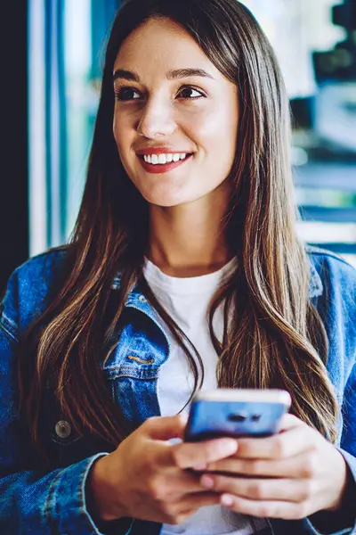 Yüzünde sevimli bir gülümsemeyle, cep telefonundan aranmayı bekleyen olumlu bir kadın. Elinde yeni akıllı telefon aleti tutan mutlu bir hippi kız. Kablosuz internete bağlı.