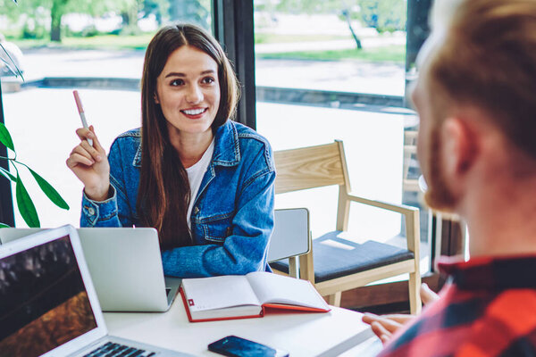 Хипстеры-мужчины и хипстеры-женщины, планирующие будущее мероприятие с друзьями из университета с помощью учебника и приложения-организатора на ноутбуках, счастливые коллеги-фрилансеры, сотрудничающие с нетбуками