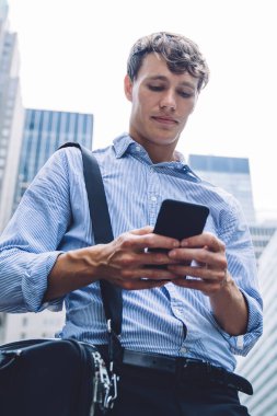 Evrak çantasıyla akıllı erkek hukukçu. Şehir merkezinde internet ve sörf yapan iş adamlarından gelen e-posta bilgilerini kontrol ediyor. Modern teknoloji kavramı.