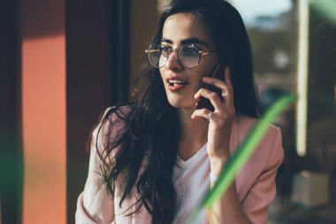 Optik gözlüklü çekici bir kadın internet danışmanlığı için müşteri hizmetlerini arıyor açık havada gezinen internet bağlantısını kullanıyor uygulamayla konuşan güzel hippi kız.