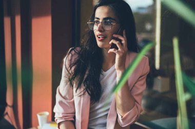 Optik gözlüklü çekici bir kadın internet danışmanlığı için müşteri hizmetlerini arıyor açık havada gezinen internet bağlantısını kullanıyor uygulamayla konuşan güzel hippi kız.