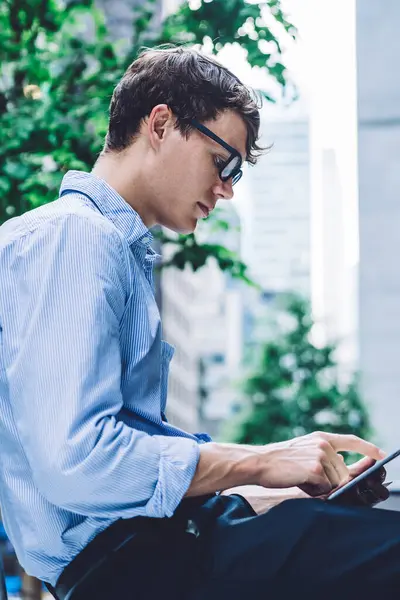 Girişimcinin, kentsel ortamlarda otururken dijital tablette sohbet edişinin yan görüntüsü, şehirde iş arasında elektronik kitap okuyan erkek avukat, uygulama yüklemek için 4G kablosuz ağ kullanıyor