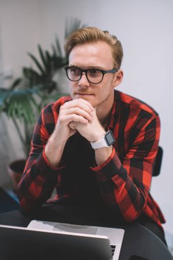 Gündelik giyinen ve akıllı saatli gözlüklü yönetici dizüstü bilgisayar kullanıyor. Kafede el ele tutuşarak işe başlamak için fikirler yaratıyor.