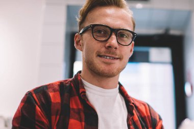 Aşağıdan gülümseyen, kendine güvenen, gözlüklü, cep telefonlu meşgul bir adamdan. Mesafe sırasında cep telefonuna göz atıyor.