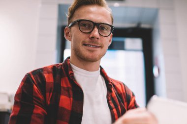 Aşağıdan gülümseyen, kendine güvenen, gözlüklü, cep telefonlu meşgul bir adamdan. Mesafe sırasında cep telefonuna göz atıyor.