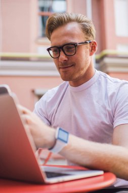 Klasik göz giyiminde, bluetooth bağlantısı kullanan bilgisayar ve akıllı telefon cihazları arasındaki medya dosyalarını paylaşan olumlu bir adam, dijital teknoloji ağ siteleri olan milenyum erkek blogcusu