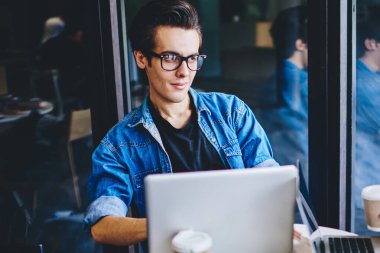 Gündelik giyinmiş iki hippi öğrenci birbirleriyle iletişim kuruyor ve modern dizüstü bilgisayarda çalışmak ve modern uzayda kablosuz internet bağlantısı kullanmak için uygulamaları tartışıyorlar.