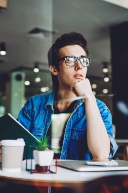 Gözlüklü, vizyon düzeltmesi için gözlüklü, düşünceli genç hippi, kafenin içinde boş zamanlarında düşünceli bakışlar atıyor ve edebiyat kitaplarının en çok satan kitabından ilginç senaryolar üzerinde kafa yoruyor.