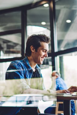 Bin yıllık neşeli hippi adamın kafeteryadaki internet bloguna bağlı takipçilerle sohbet ederken kendini iyi hissetmesi kafeteryada şakalar arayan mutlu bir adam.