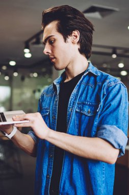 Üniversite kafeteryasında iyi bir wifi internet arama hizmeti sunucusu seçen ciddi öğrenci, gitmeden önce bilgisayarla işten e-posta okuyan konsantre bir erkek serbest yazar