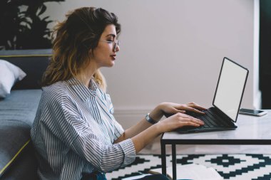 İnternet sitesinde ders çalışması için bilgi aramak için dizüstü bilgisayarında yazı yazan beyaz kadın, Netbook 'ta boş ekran ile uzaktan çalışan hipster kız.