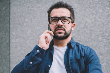 Düşünceli hippi, gündelik giysiler giymiş. İnternette gezinen internet, teknoloji ve iletişim konsepti hakkında konuşmak ve danışmanlık yapmak için internetten telefon görüşmesi yapıyor.