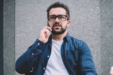 Düşünceli hippi, gündelik giysiler giymiş. İnternette gezinen internet, teknoloji ve iletişim konsepti hakkında konuşmak ve danışmanlık yapmak için internetten telefon görüşmesi yapıyor.