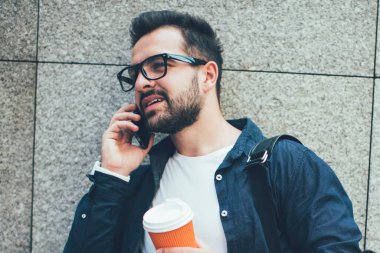 Arkadaşlarıyla uluslararası sohbetlerde 4 G 'lik günlük kıyafet giyen ciddi bir erkek. Seyahat kaçamağı, çevrimiçi başvuru yoluyla sırt çantalı şık bir turist.