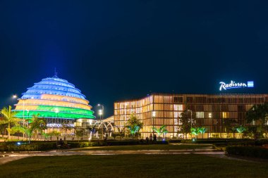 Kigali, Ruanda - 19 Ağustos 2022: Geceleyin Kigali Kongre Merkezi, Rwandan bayrağının renkleriyle aydınlandı. Tesis çeşitli etkinliklere ev sahipliği yapmak üzere tasarlandı ve şehirde en çok ilgi çeken yer..