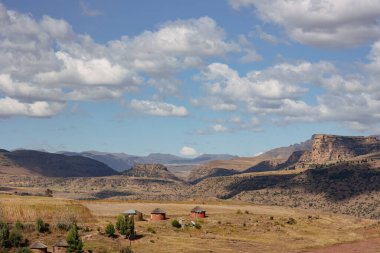 Lesotho dağlık ülkesinde çimenli bir ovada kulübeler
