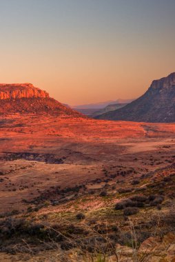 Lesotho dağlarındaki tepeler gün batımında kıpkırmızı parlar.