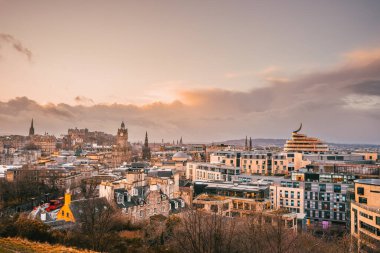 Calton Hill 'den Edinburgh ufuk çizgisinin günbatımı manzarası, ikonik binalar görünür.