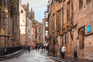 Edinburgh, İskoçya - 22 Ocak 2024: Castlehill 'in dar kaldırımlı caddesi, eski binaların arasından Edinburgh Kalesi' ne doğru gidiyor.