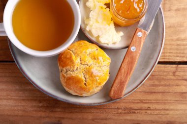 Homemade scones served with butter and marmalade and cup of tea