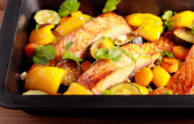 Roast salmon with vegetables on baking tray