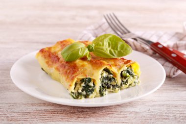 Ricotta and spinach filling cannelloni, served on plate