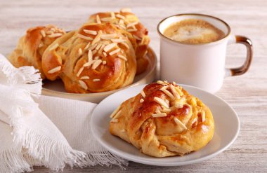 Kremalı ve bademli çörekler, kahveyle servis edilir.