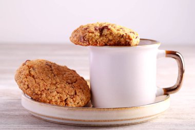 Çikolatalı ve fındıklı yulaf ezmeli kurabiyeler, sade kahveyle servis edilir.