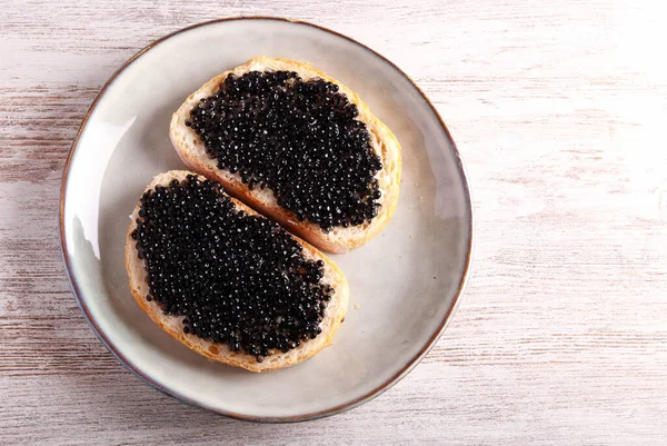 stock image Black caviar over slices of white bread