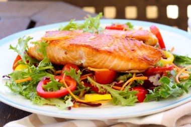 Salata üzerine kızarmış somon filetosu.