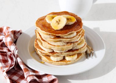 Tabağında bal olan muzlu krep yığını.