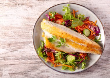 Kızarmış deniz kabuğu fileto salata üzerine.