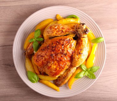 Tabakta patates ile kızarmış bütün tavuk