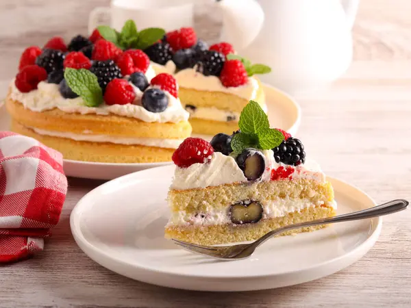 Cream and mixed berry sandwich cake, served