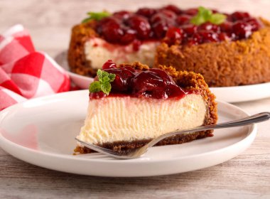 Ev yapımı kiraz soslu peynirli kek dilimi tabakta