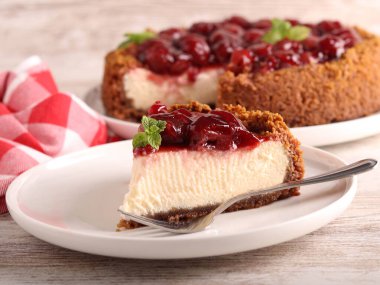 Ev yapımı kiraz soslu peynirli kek dilimi tabakta