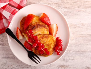 Kır peynirli börek, tabakta çilek.