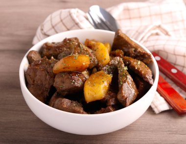 Baharatlı ciğer ve elma, kasede.