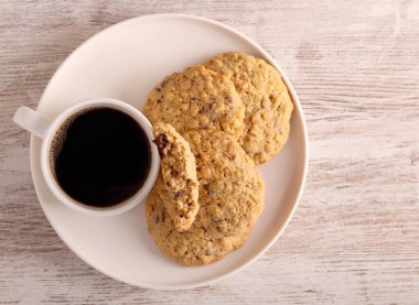 Bir fincan kahveli yulaflı çikolatalı kurabiye.